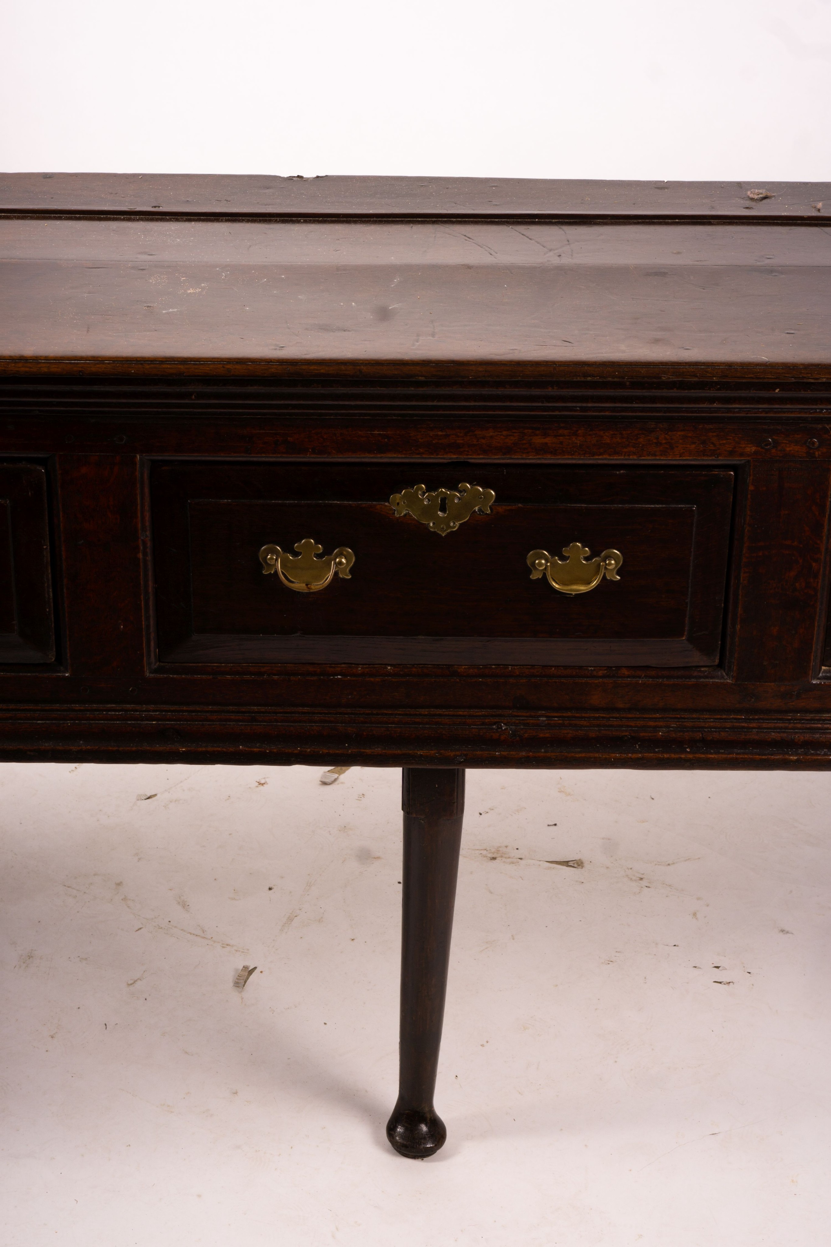 An 18th century oak low dresser on pole turned legs and pad feet, length 198cm, depth 53cm, height 88cm